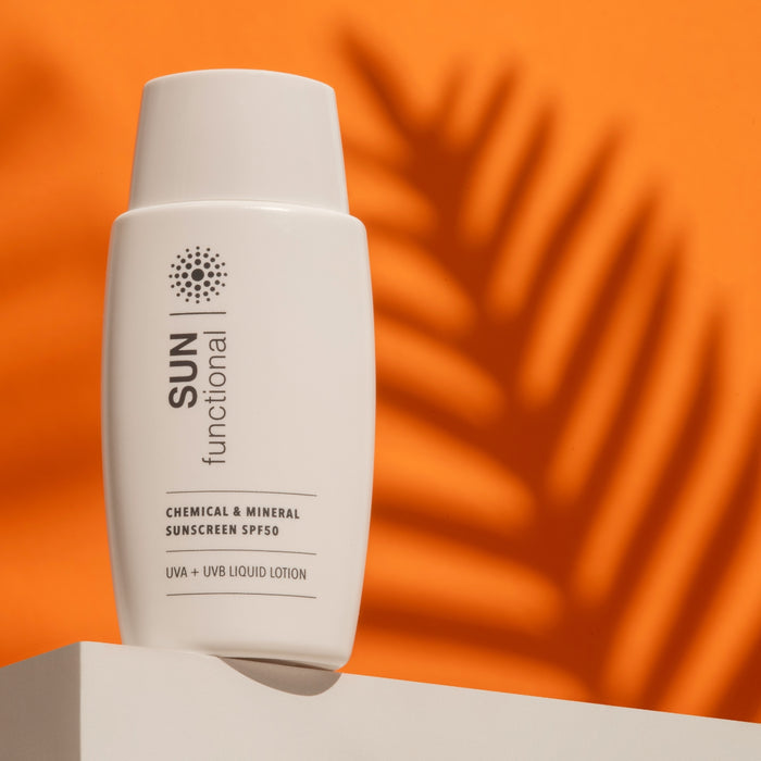 Sunscreen bottle labeled 'SUN functional' on an orange background with leaf shadows