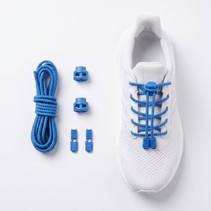 Blue elastic speed laces with plastic toggle clips and a coiled cord, shown next to a white athletic shoe on a clean white background.