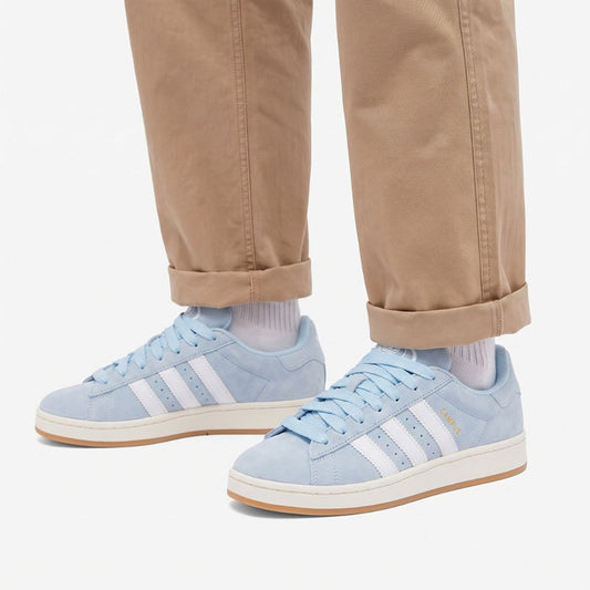 Model wearing Clear Sky Gum Adidas Campus 00s with light blue 15mm wide replacement laces in a clean studio setting by Kicks Shoelaces