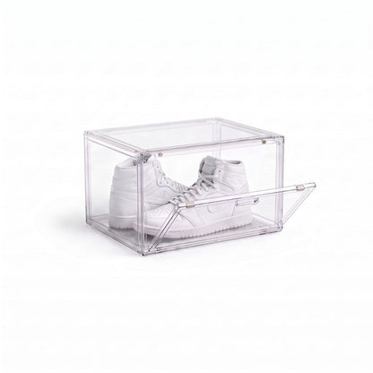 Clear shoe display box with magnetic drop-down door holding a pair of white high-top sneakers