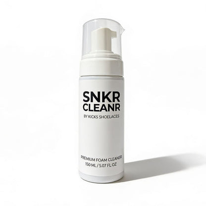 A white bottle of SNKR Cleaner Premium Foam Cleaner by Kicks Shoelaces, featuring a clear cap and white pump dispenser, set against a clean white background with a soft shadow.