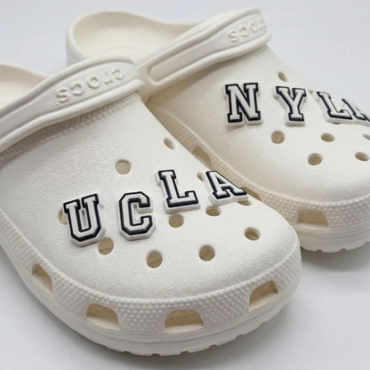 Crocs with varsity letter charms by Kicks Shoelaces.