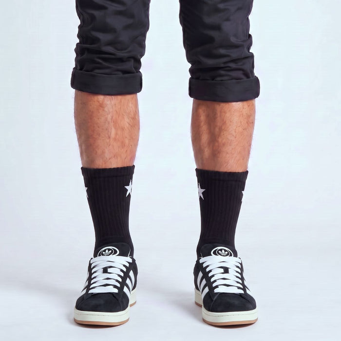 Model wearing Core Black Adidas Campus 00s with white 15mm wide replacement laces in a clean studio setting by Kicks Shoelaces